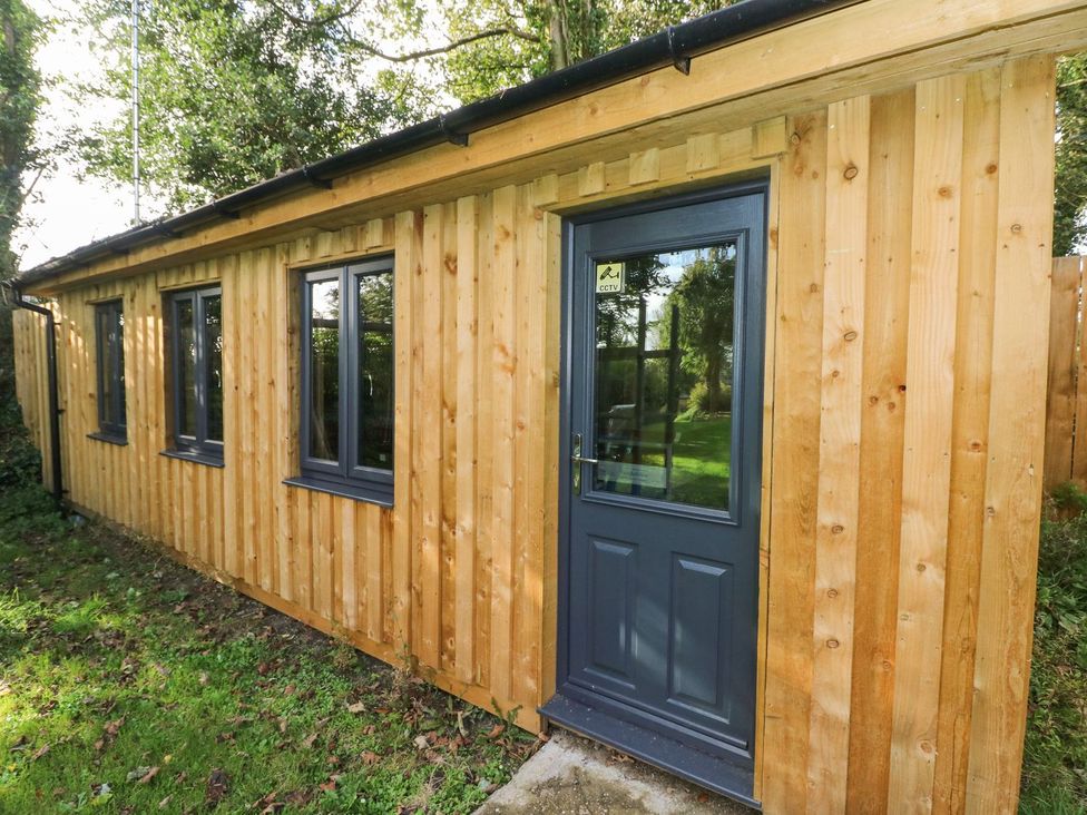 A wooden building with windows and a door at Rafters Cottage Clarbeston Road
