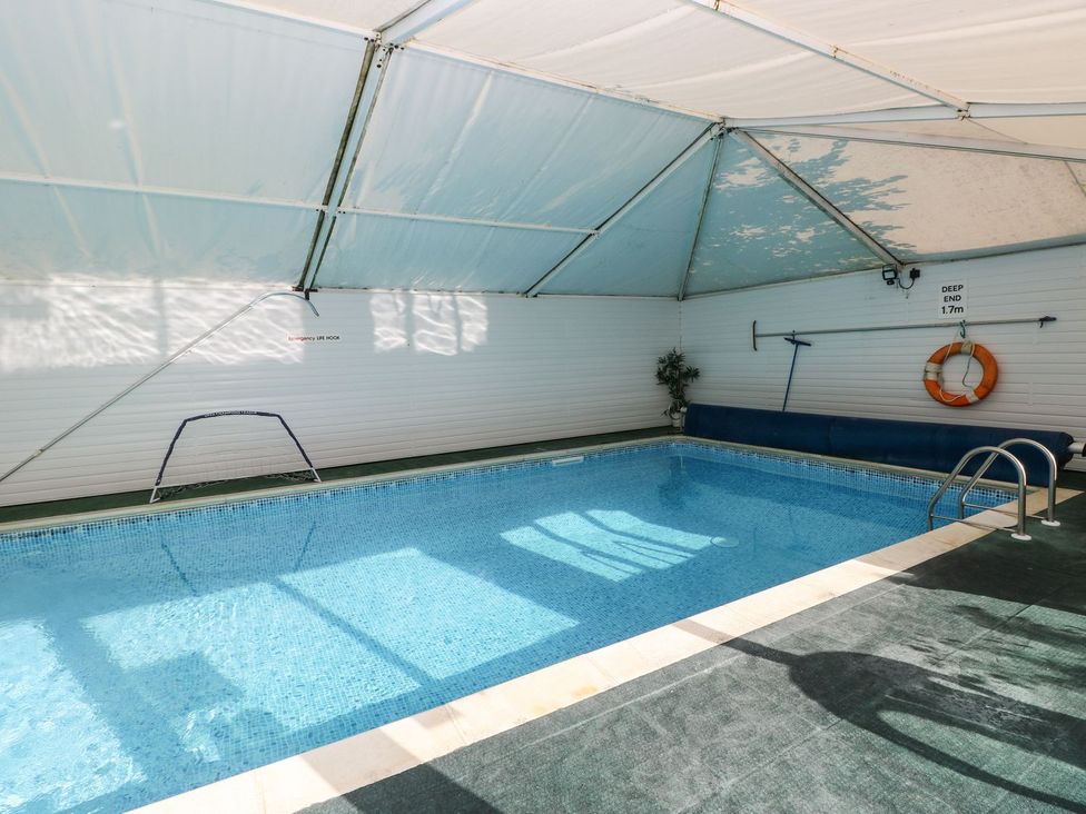 An indoor pool with a handrail and lifebuoy at Rafters Cottage Clarbeston Road