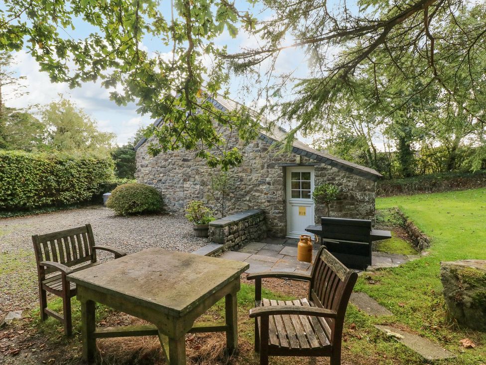 An outdoor seating area with chairs and a table at Rafters Cottage in Clarbeston Road