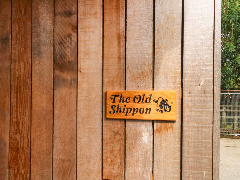 A sign on a wooden wall outside The Old Shippon