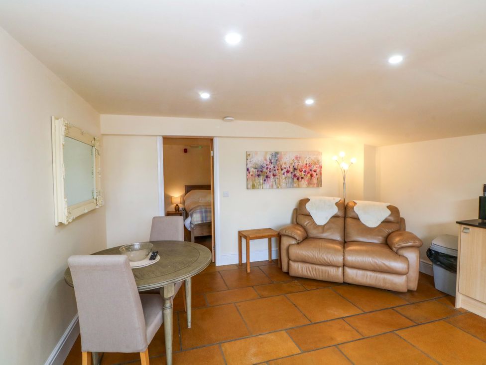 A living room with a sofa and dining table at The Old Shippon