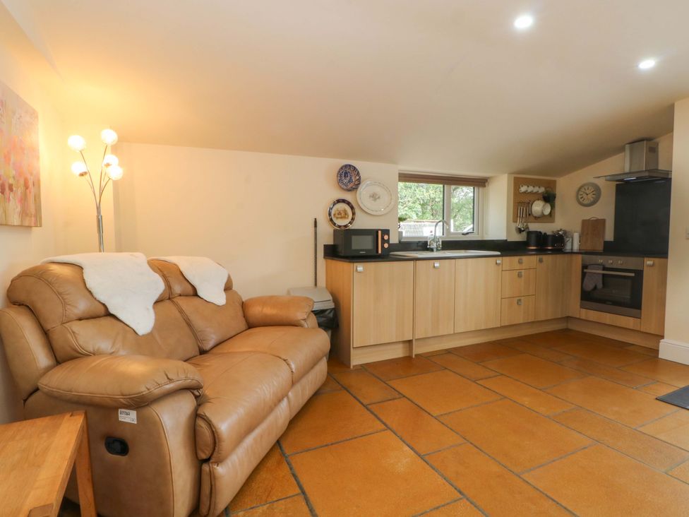 A kitchen with a sofa and appliances at The Old Shippon 