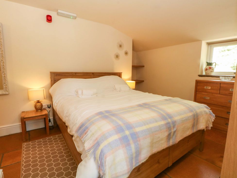A bedroom with a bed and dresser at The Old Shippon 