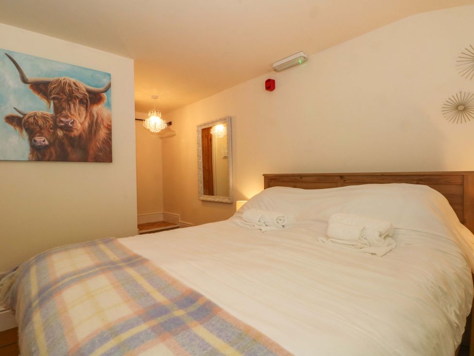 A bedroom with a bed and artwork at The Old Shippon 