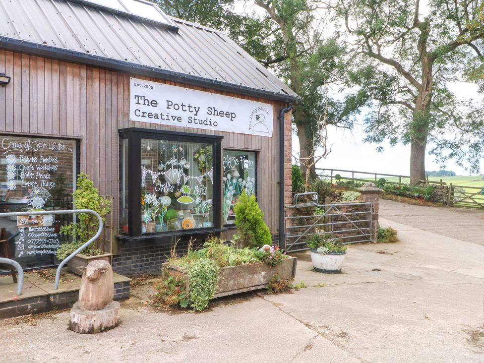 An outdoor view of The Potty Sheep Creative Studio with signage and landscaping