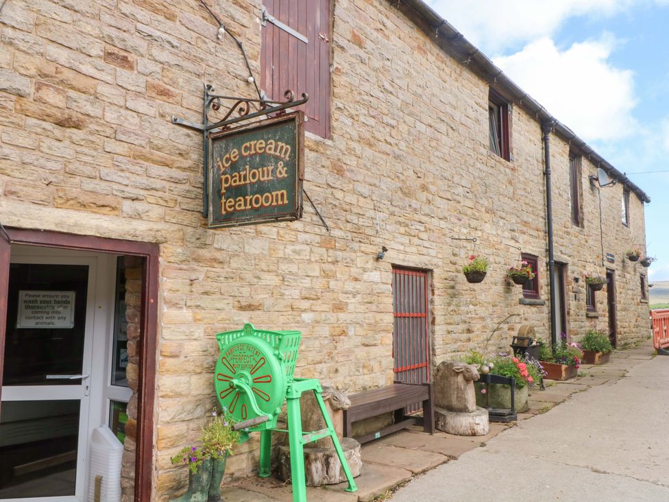 An outdoor area with signage and stone building at The Old Shippon in 