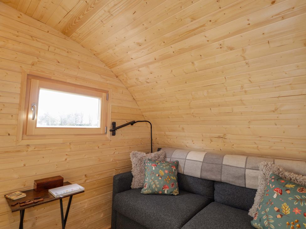 A seating area with a sofa and a window at Little Oaks in Poyntzfield near Cromarty