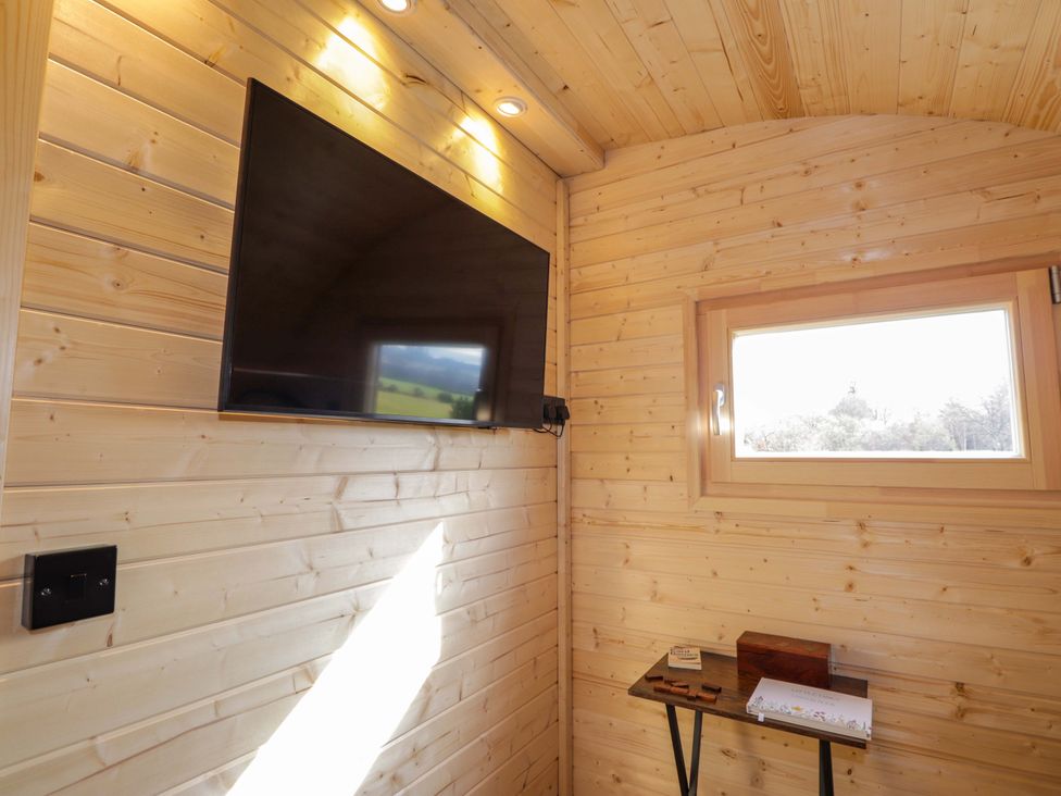 A room with a television and a small table at Little Oaks in Poyntzfield near Cromarty