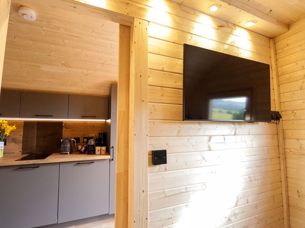 A kitchen with cabinets and a television at Little Oaks in Poyntzfield near Cromarty