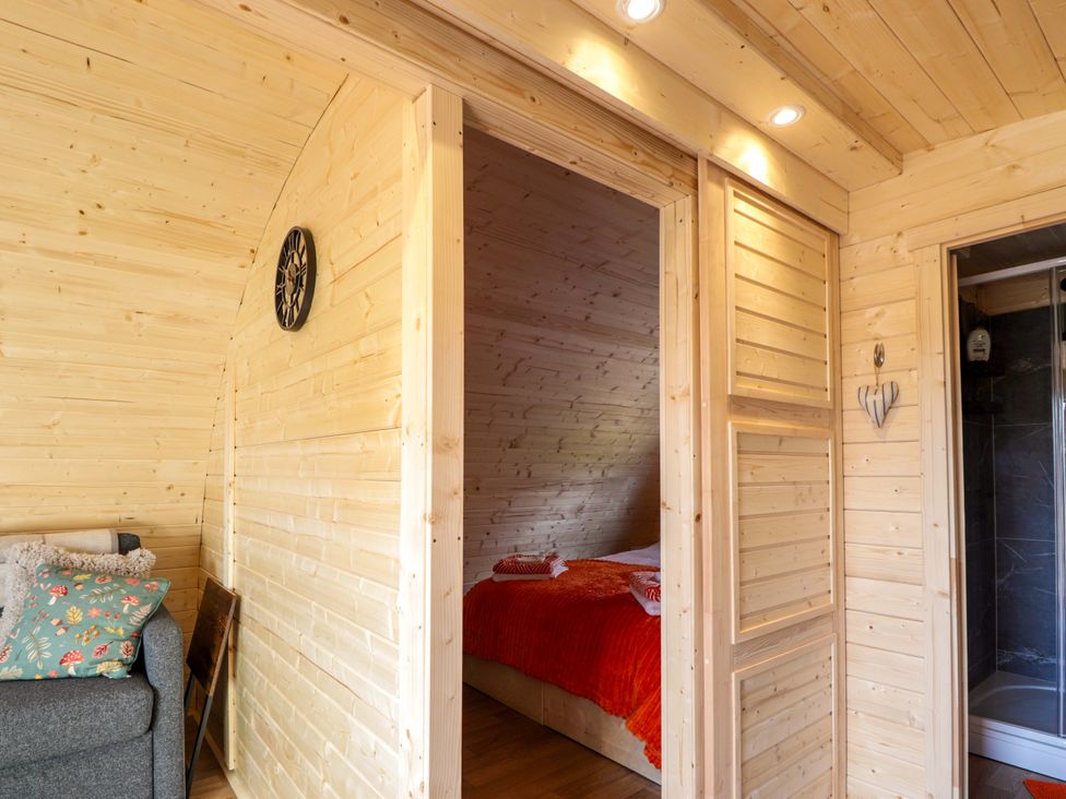 A bedroom with a bed and a shower at Little Oaks in Poyntzfield near Cromarty