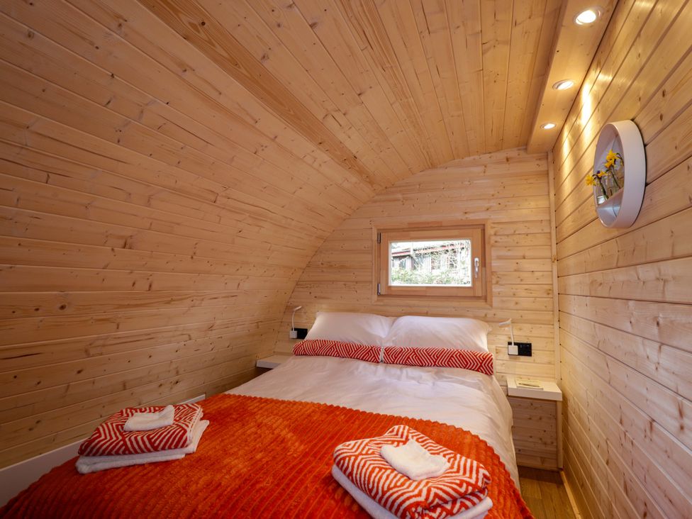 A bedroom with a bed and a window at Little Oaks in Poyntzfield near Cromarty