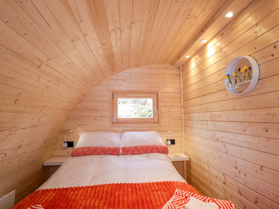 A bedroom with a bed and a window at Little Oaks in Poyntzfield near Cromarty