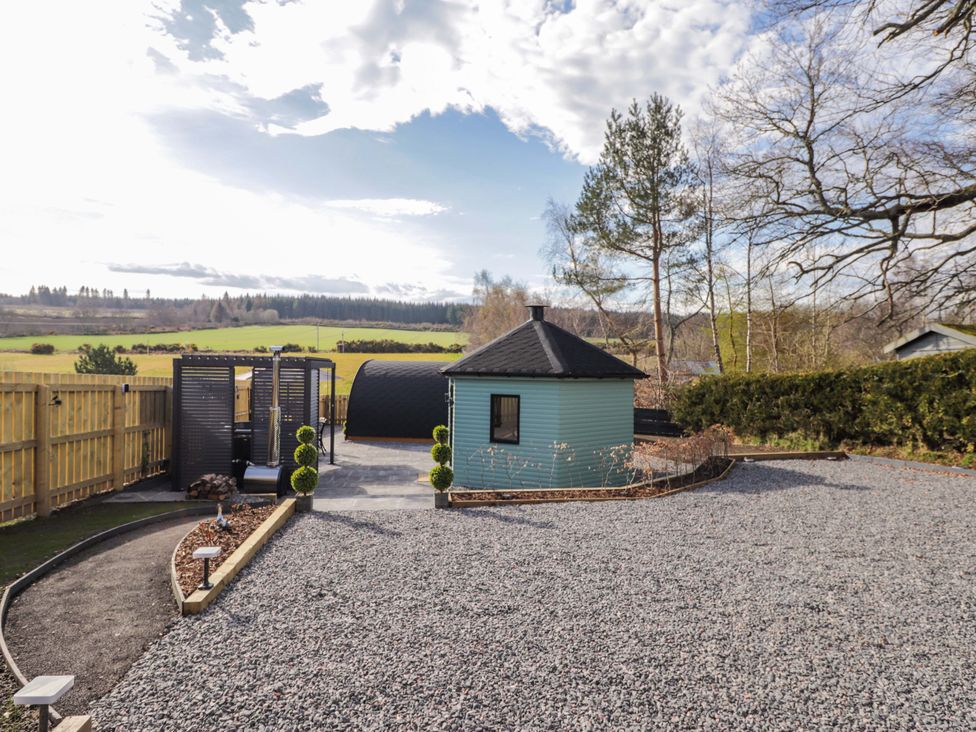 A garden with a hut and gravel area at Little Oaks Poyntzfield near Cromarty