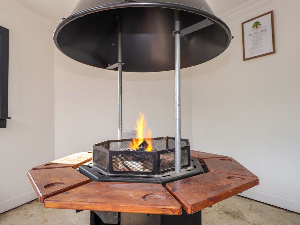 A fire pit with a wooden table in The Oak Tree in Poyntzfield near Cromarty