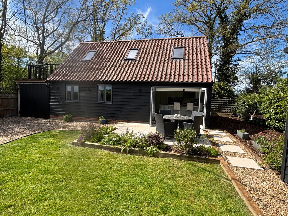 A house with a garden and seating area at Ash Tree Lodge in Norwich