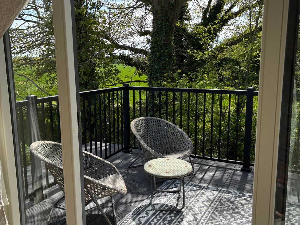A balcony with chairs and a side table at Ash Tree Lodge in Norwich