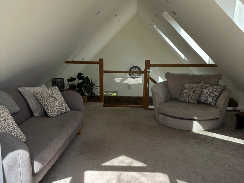 A living room with a sofa and armchair at Ash Tree Lodge in Norwich