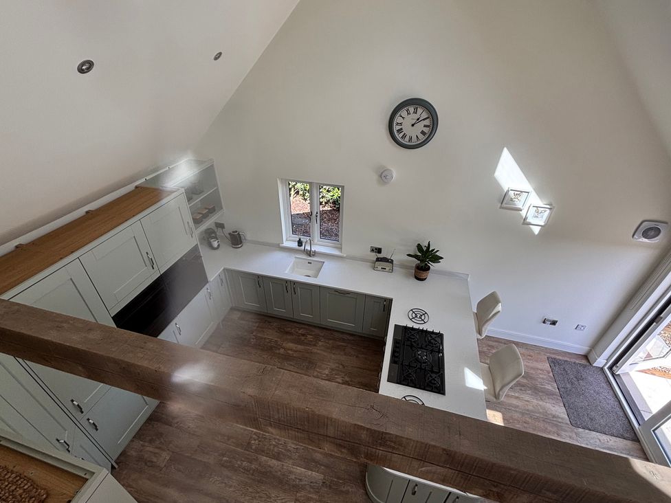 A kitchen with cabinets, stove, and sink at Ash Tree Lodge in Norwich