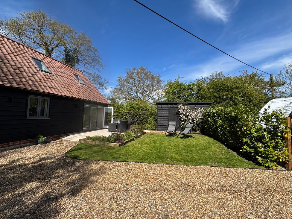 A garden with chairs and a shed at Ash Tree Lodge in Norwich