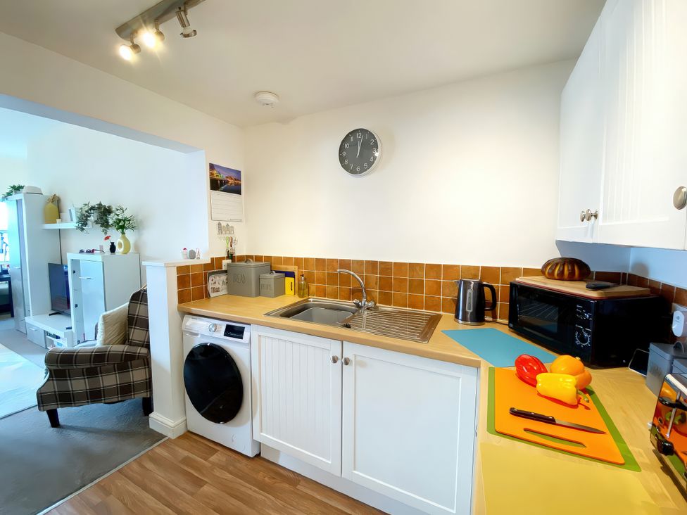 A kitchen with a sink and washing machine at Number 1 Marina Court in Torquay