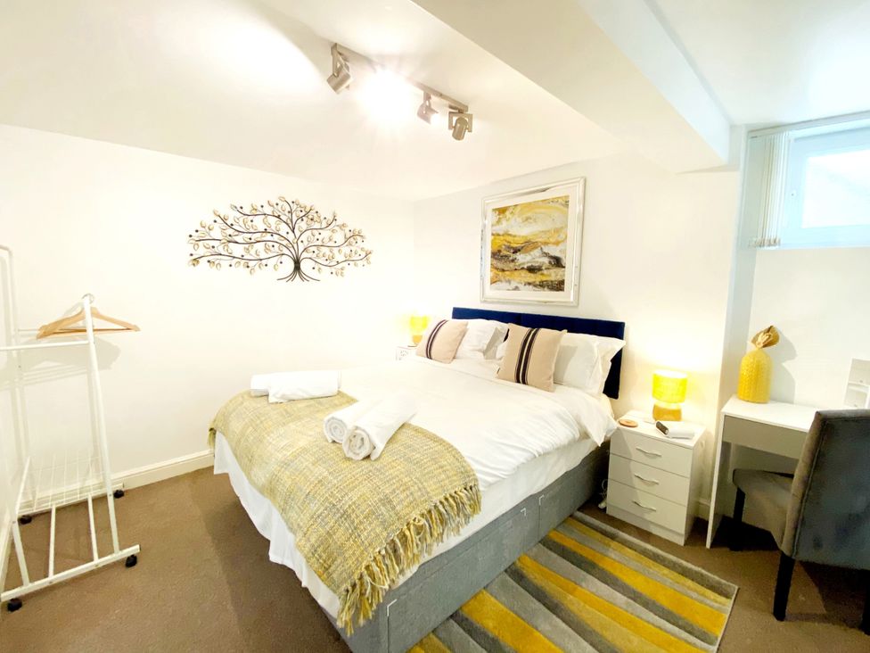A bedroom with a bed, bedside table, and wall art at Number 1 Marina Court in Torquay