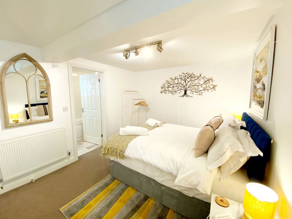 A bedroom with a bed and mirror at Number 1 Marina Court in Torquay