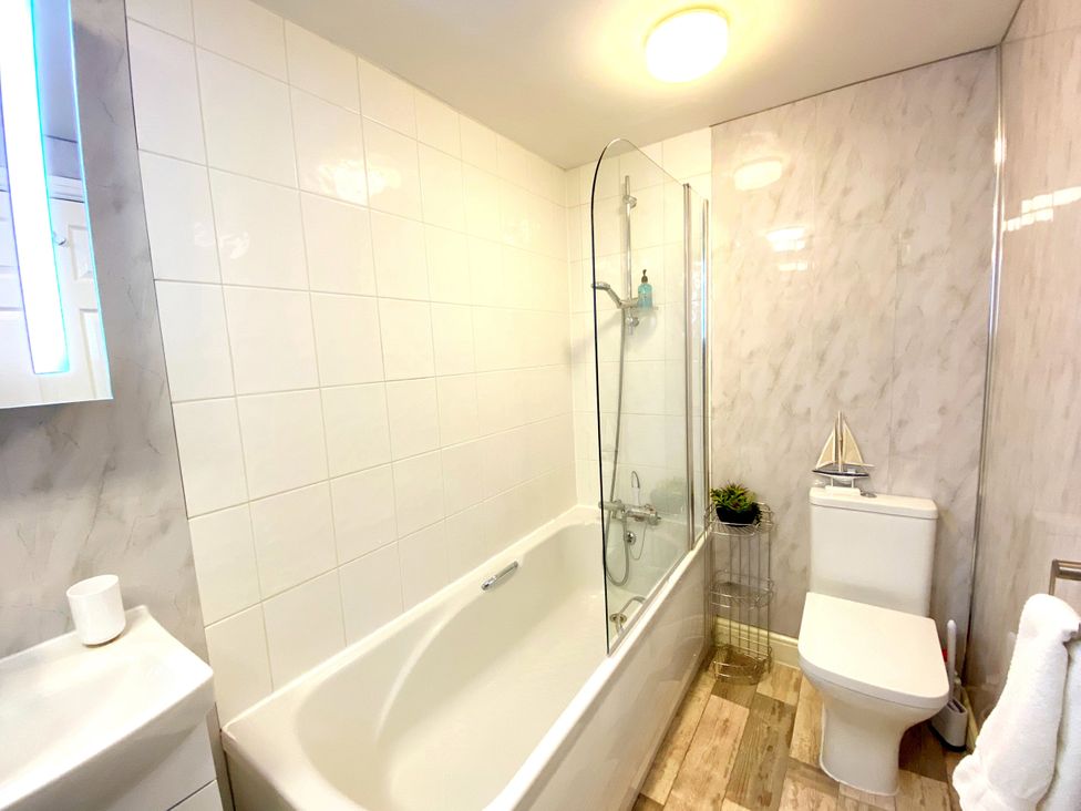 A bathroom with a bathtub, toilet, and sink at Number 1 Marina Court in Torquay