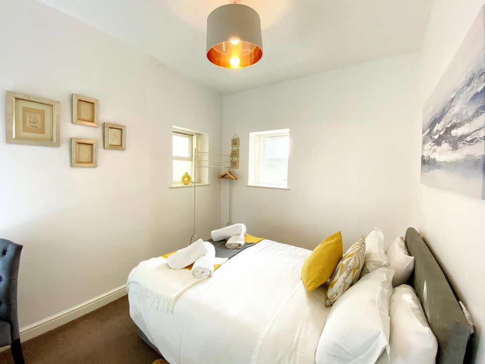 A bedroom with a bed and artwork on the wall at Number 1 Marina Court in Torquay