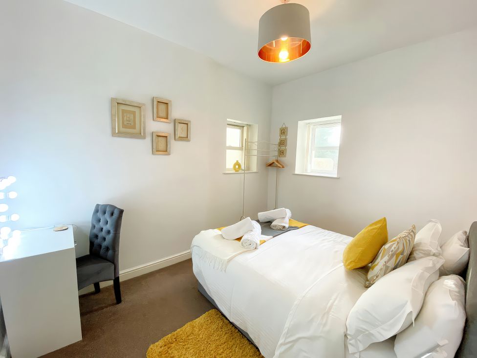 A bedroom with a bed and desk at Number 1 Marina Court in Torquay