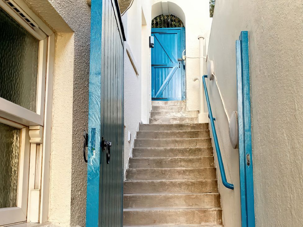 An outdoor staircase leading to a blue door at Number 1 Marina Court in Torquay