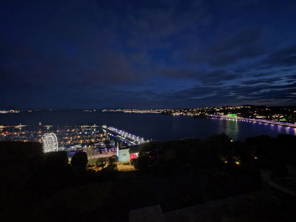 A view of a marina and waterfront at night with lights at Number 1 Marina Court, Torquay
