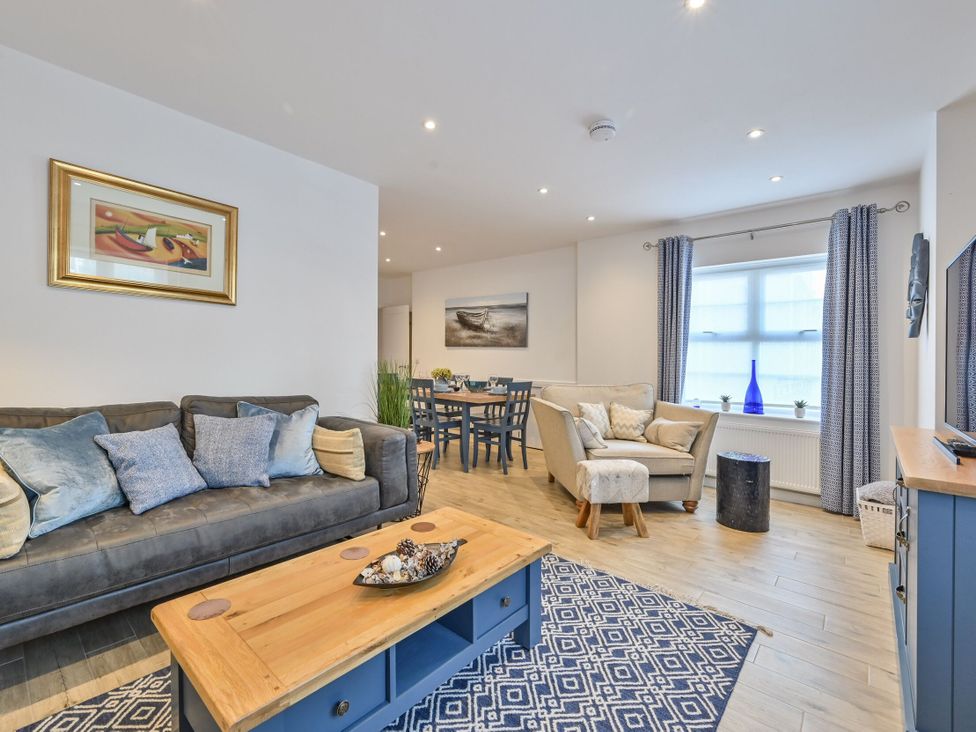 A living room with a sofa, coffee table and dining table at Number 2 Ellington Court Apartment in Torquay