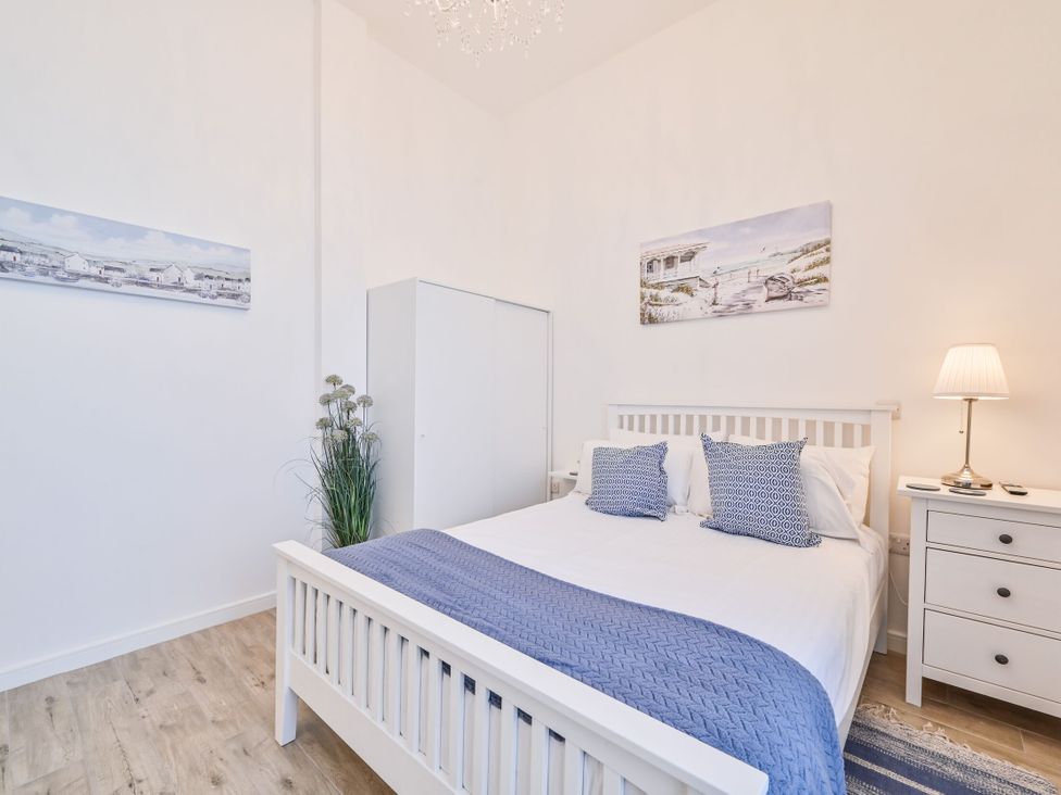 A bedroom with a bed and wardrobe at Number 2 Ellington Court Apartment Torquay