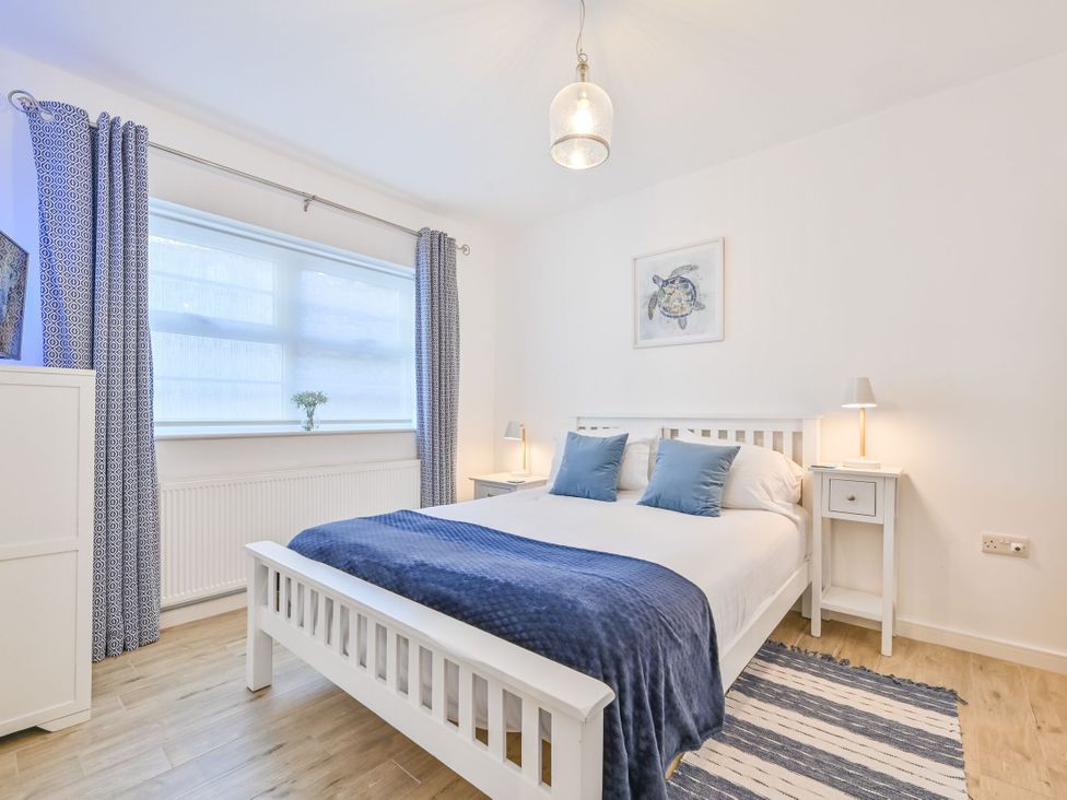 A bedroom with a bed and side tables at Number 2 Ellington Court Apartment in Torquay