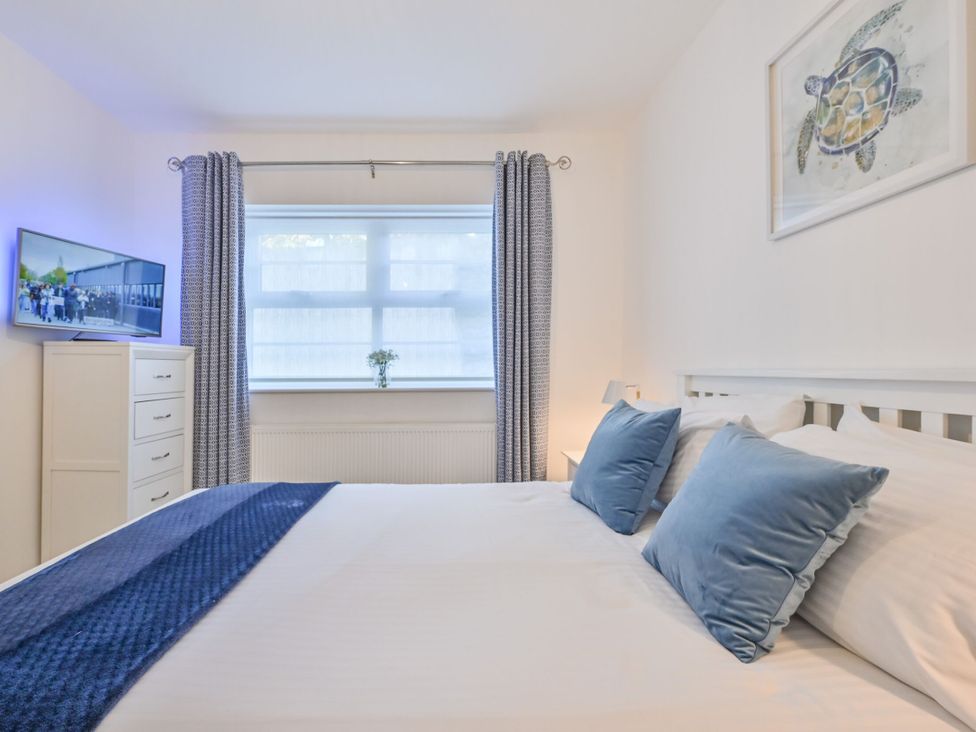 A bedroom with a bed, television and dresser at Number 2 Ellington Court Apartment, Torquay