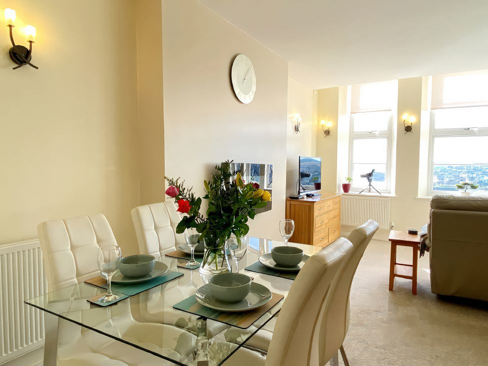 A dining room with a glass table and chairs at Sea View Apartment, Ellington Court in Torquay