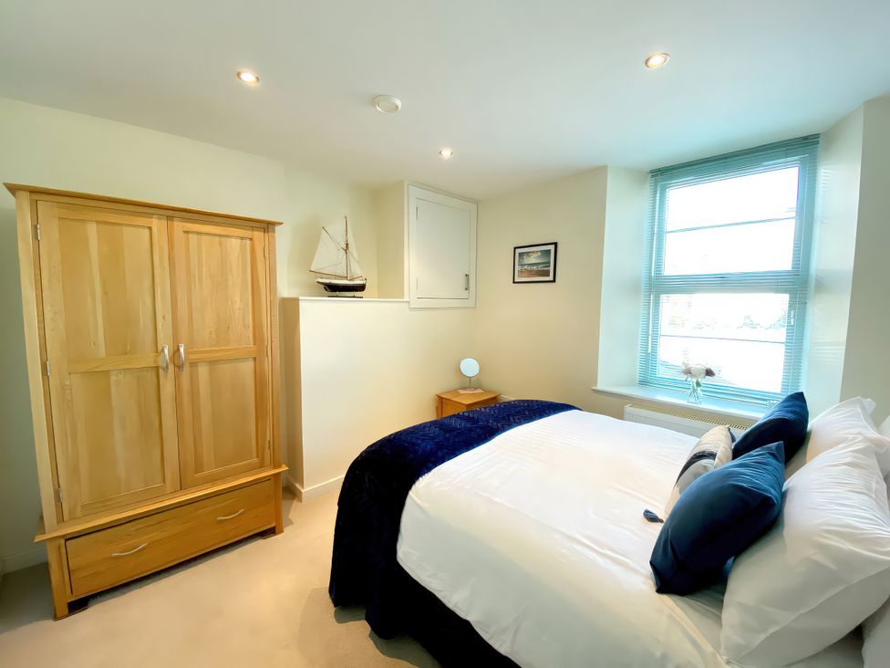 A bedroom with a bed and a wardrobe at Sea View Apartment, Ellington Court, Torquay