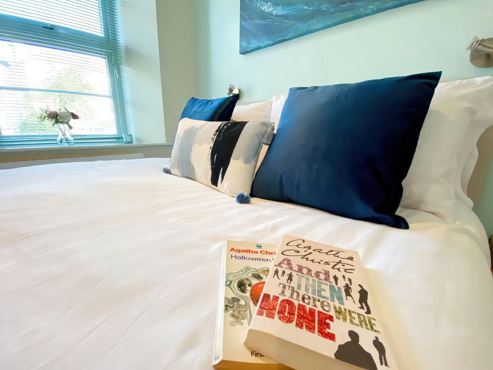 A bedroom with a bed and books on it at Sea View Apartment, Ellington Court in Torquay
