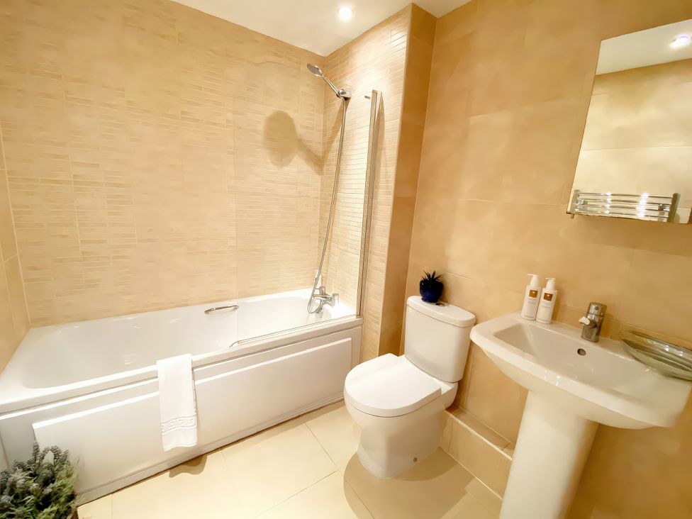 A bathroom with a bathtub, toilet, and sink at Sea View Apartment, Ellington Court in Torquay
