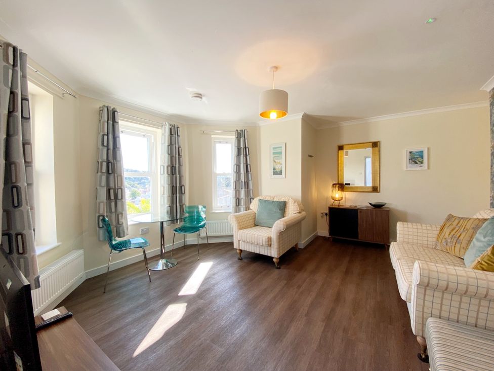 A living room with seating and a table at Ockedon House Apartment A in Torquay