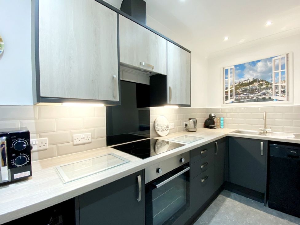 A kitchen with cabinets and appliances at Ockedon House Apartment A Torquay
