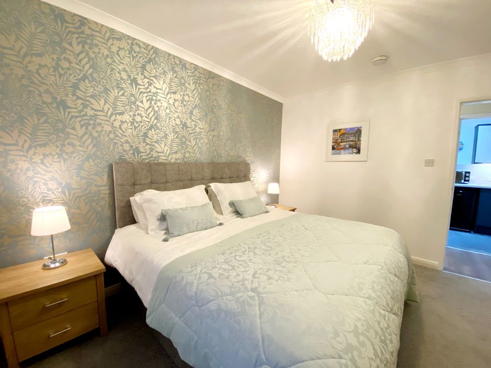 A bedroom with a bed and bedside tables at Ockedon House Apartment A Torquay