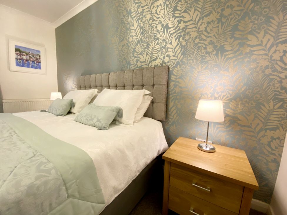 A bedroom with a bed and bedside table at Ockedon House Apartment A in Torquay