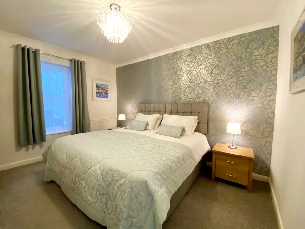 A bedroom with a bed and bedside table at Ockedon House Apartment A in Torquay