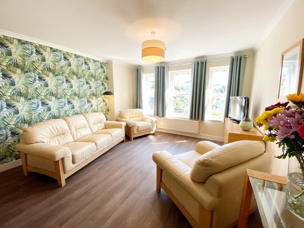 A living room with sofas and a television at Ockendon House Apartment B in Torquay