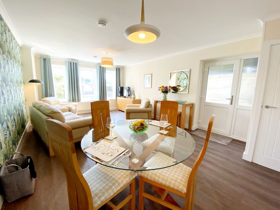 A living room with a sofa and dining table at Ockendon House Apartment B Torquay