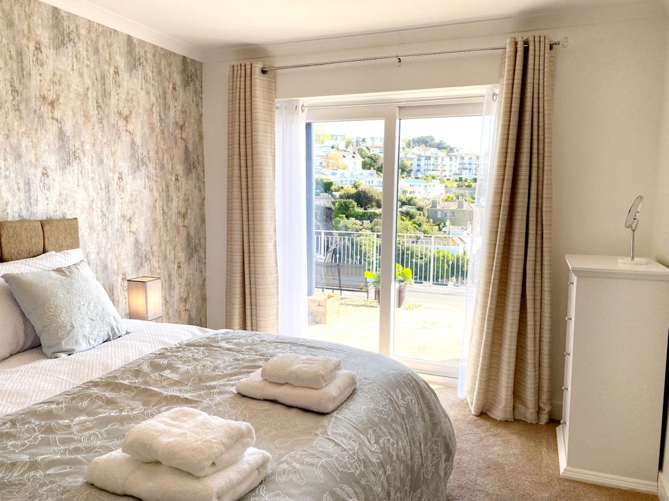 A bedroom with a bed and balcony door at Ockendon House Apartment B Torquay