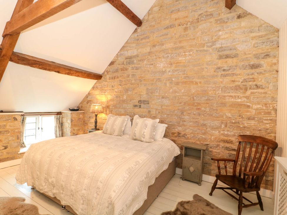 A bedroom with a bed and a wooden chair at The Farmhouse in Langport