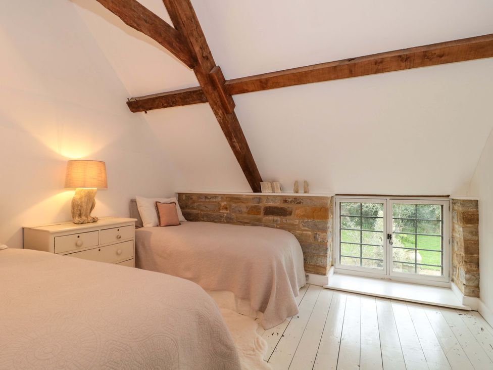 A bedroom with two beds and a window at The Farmhouse in Langport