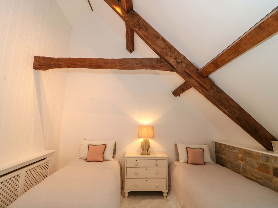 A bedroom with two beds and a dresser at The Farmhouse in Langport